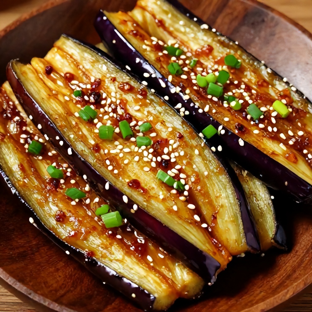 Miso glazed eggplant slices on a plate with green onions and sesame seeds