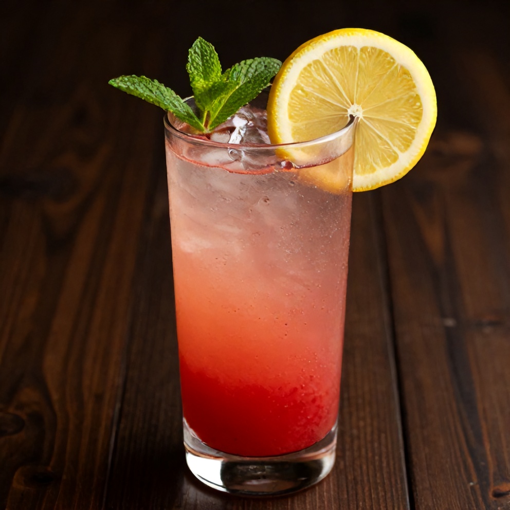 Glass of strawberry mint lemonade with a lemon wheel and mint sprig