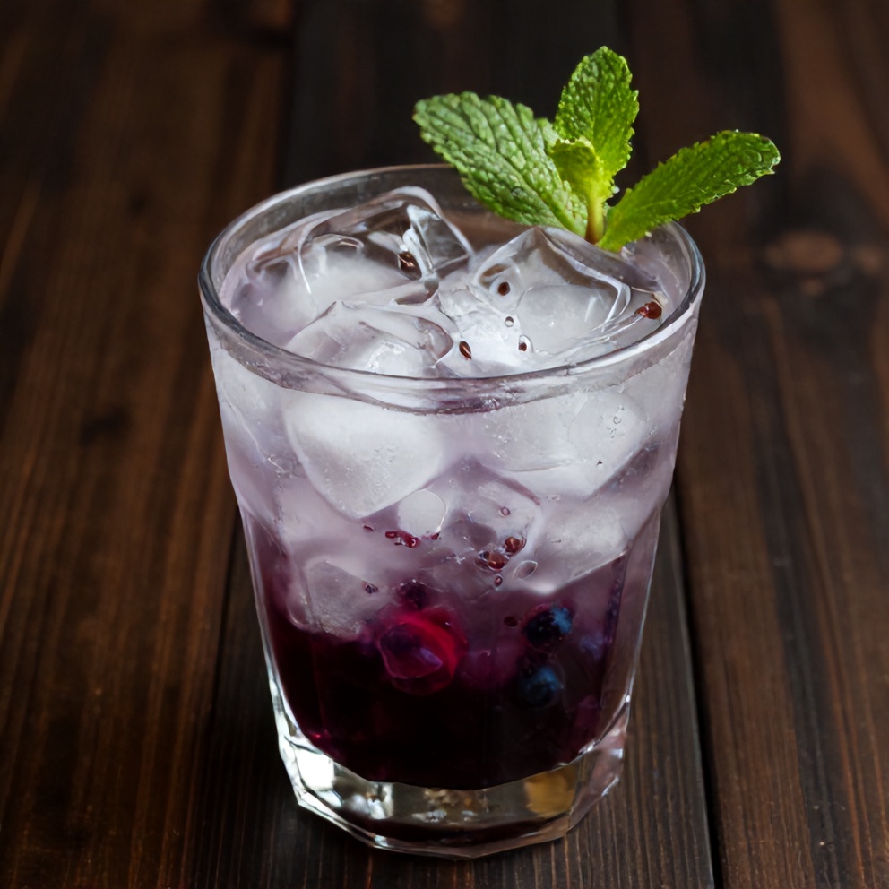 Blueberry syrup poured over ice in a glass