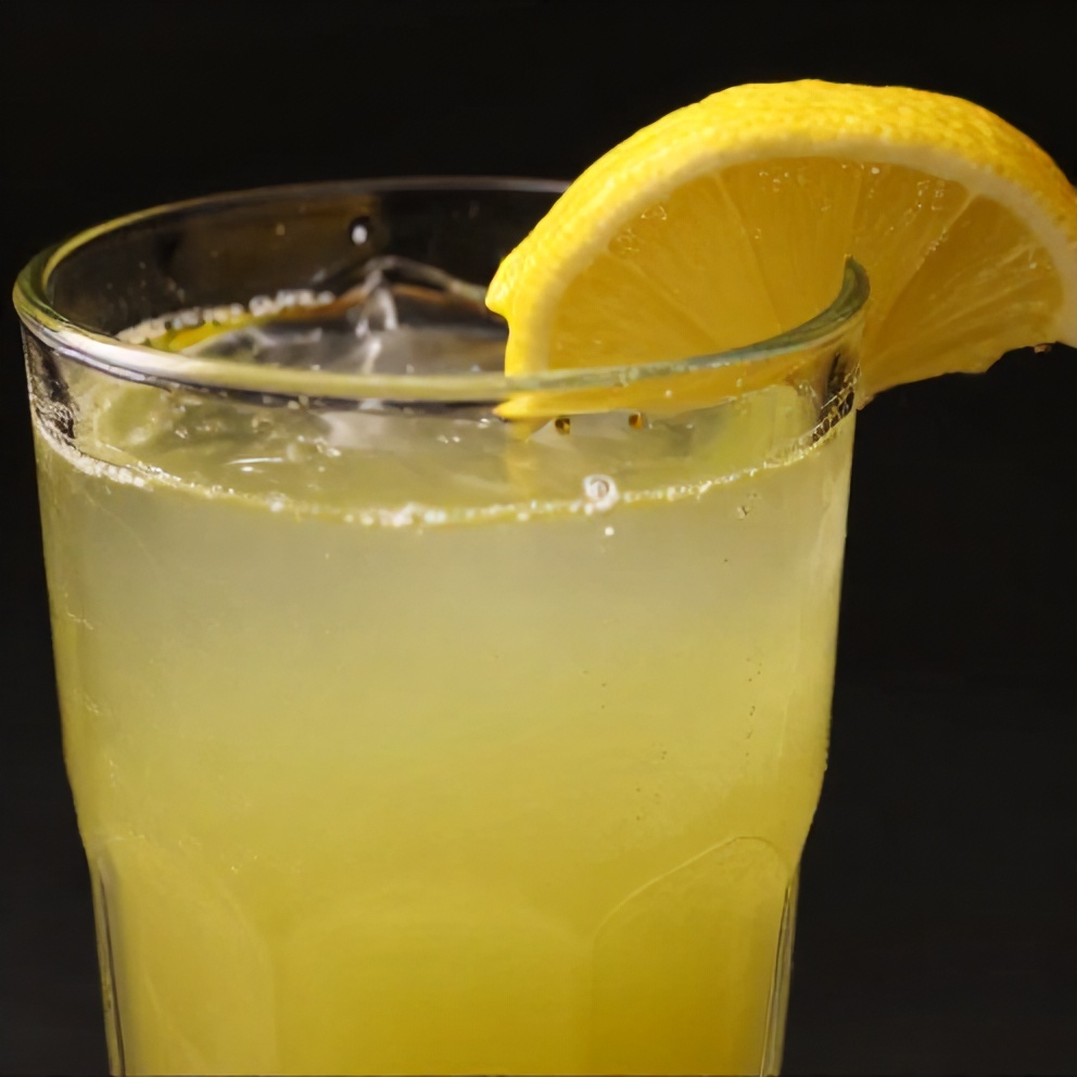 Celery apple juice poured in a glass with a lemon slice garnish